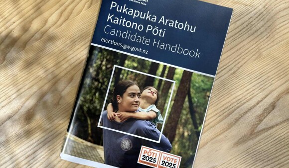A copy of the 2025 Candidate Handbook on a table
