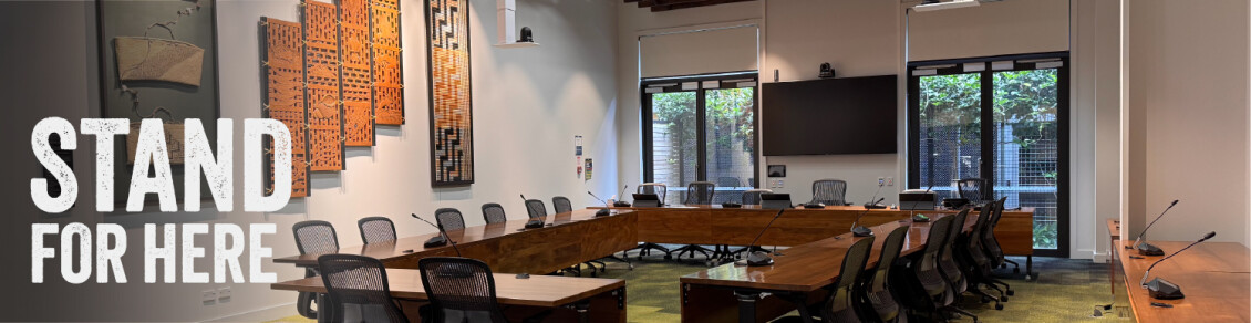 The council chamber at Greater Wellington Cuba Street office sans people with the words "Stand for here"